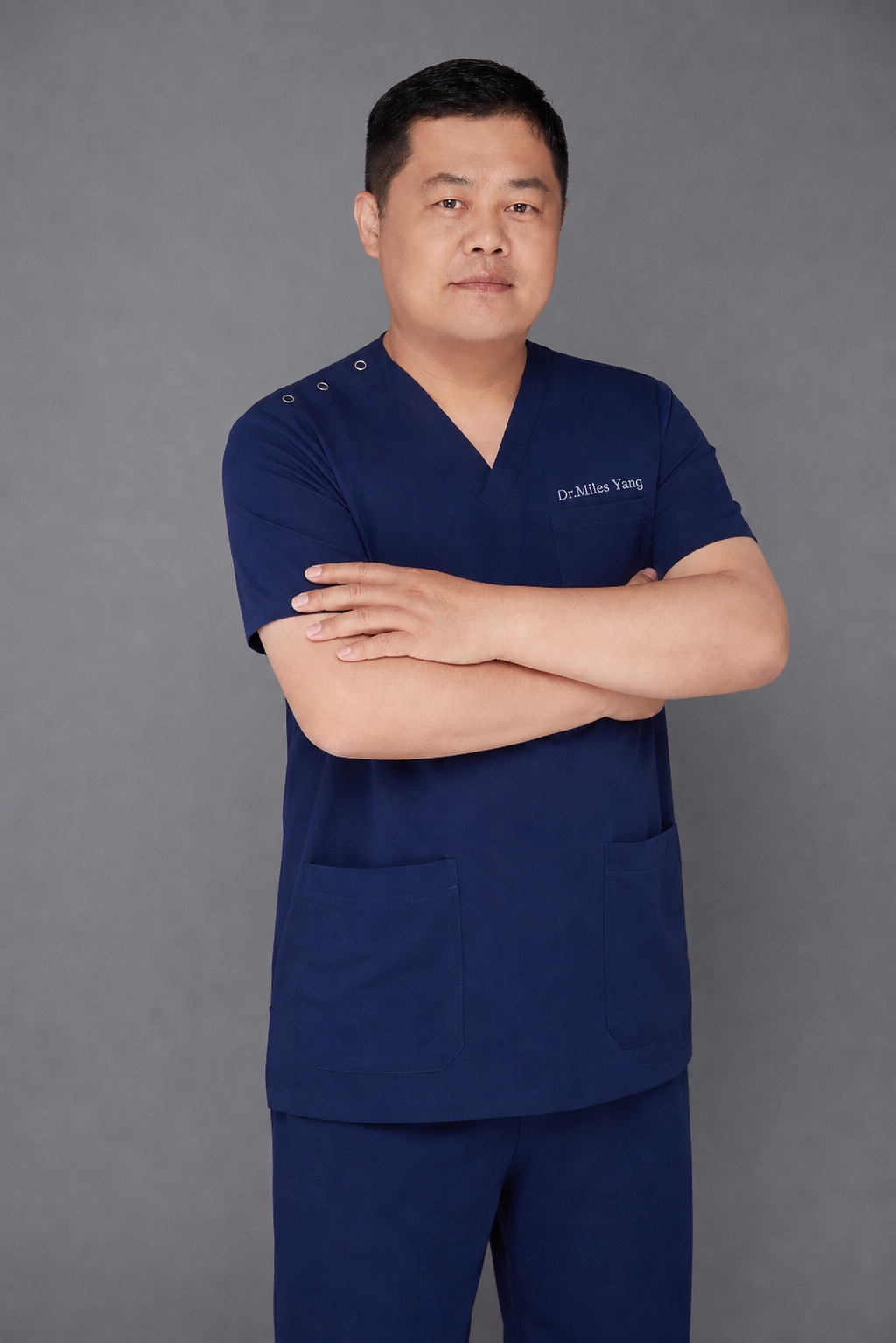 Dr. Miles in navy surgical scrubs